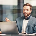 Group of business people talking in a conference room with a computer