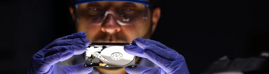 Digital forensic specialist examining a computer hard drive.