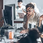 Two cybersecurity professionals looking at computer screens