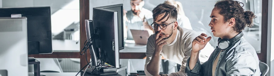 Two cybersecurity professionals looking at computer screens